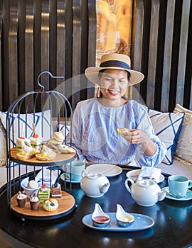 Asian women having a Luxury high tea with snack and tea in a luxury hotel