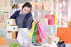 Asian women Hold a parcel box and bag. SME online shopping business concept.