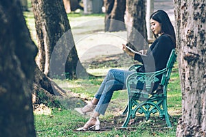 Asian women with long hair in work clothes Happily reading business papers in the park