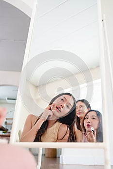 Asian women looking at mirror