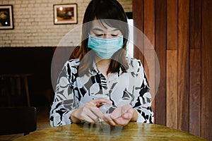 Asian women in medical mask and using alcohol