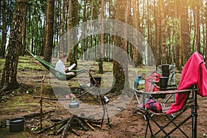 Asian women natural travel relax in the holiday. sitting reading a book in the hammock. camping on the national park  Doi inthanon