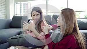 Asian women playing pillow fight and eating popcorn in living room at home, group of roommate friend enjoy funny moment.