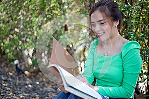 Asian women reading book and smiling and happy Relaxing in a coffee shop after working in a successful office