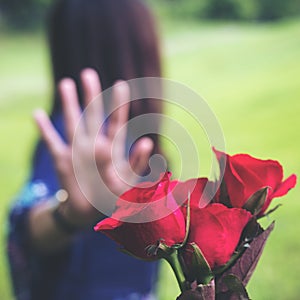 An Asian women rejecting a red rose flower from her boyfriend on Valentine`s day with nature