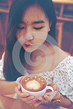 Asian women relax with hot coffee latte art with space