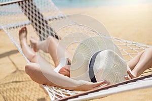 Asian women relaxing in hammock summer holiday on beach