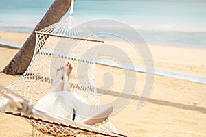 Asian women relaxing in hammock summer holiday on beach