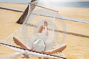 Asian women relaxing in hammock summer holiday on beach