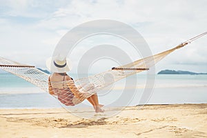 Asian women relaxing in hammock summer holiday on beach