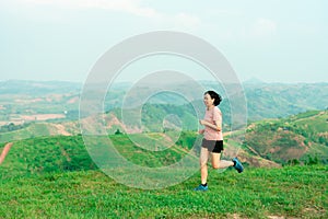 Asian women runner training on a high mountain. The back view is high mountain, beautiful scenery. In the evening the air is fresh