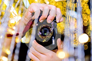 Asian women`s hand Holding the camera to take pictures. with bokeh