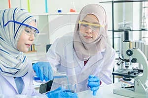 Asian women scientist with test tube making research in clinical laboratory.Science Oil pouring, Formulating the chemical for