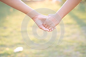 Asian women shaking hands in the warmth of the morning light.