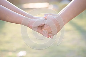 Asian women shaking hands in the warmth of the morning light.