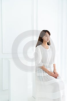 Asian women sit on white stool in  black lace fabric costume in white  backgroud / harmony  concept / fashion concept/ copy space