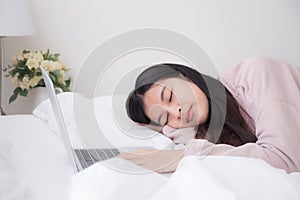 Asian women are sleeping because they are tired of work from laptop computer at bedroom, concept lifestyle and work at home