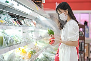 Asian women and surgical mask shopping some food in supermarket, covid-19 crisis