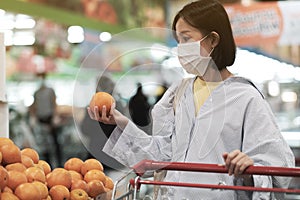 Asian women and surgical mask shopping some food in supermarket, covid-19 crisis