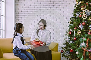 Asian woman surpise with christmas gift box from younger sister at home,Happy and smiling