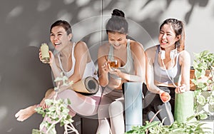 Asian women talking and laughing together after yoga class