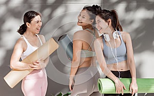 Asian women talking and laughing together after yoga class