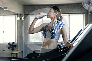 Asian women thirsty drinking water after exercise in fitness gym