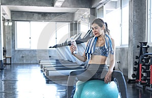 Asian women thirsty drinking water after exercise in fitness gym. healthy lifestyle