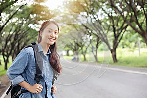 Asian women tourists and backpackers waiting car and Freedom traveler woman standing with raised arms at the roadside