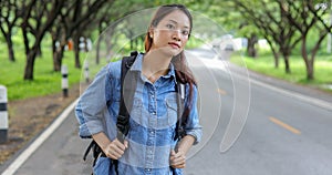 Asian women tourists and backpackers waiting car and Freedom traveler woman standing with raised arms at the roadside