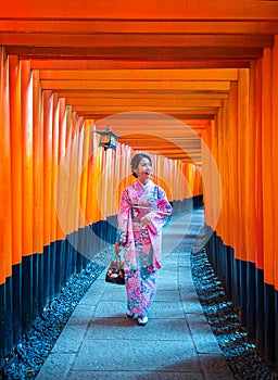 Asian women in traditional japanese kimonos at Fushimi Inari Shrine in Kyoto, Japan photo