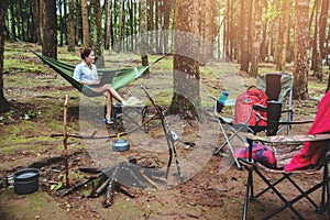 Asian women travel natural relax . Sitting working using a notebook. in the hammock. campsite on the national park  Doi inthanon