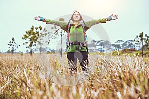 Asian women travel  nature. Travel relax.Backpack walk on the meadow in the forest. Thailand