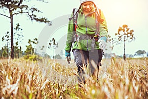 Asian women travel  nature. Travel relax.Backpack walk on the meadow in the forest. Thailand