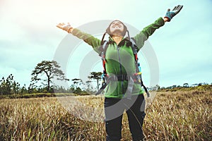 Asian women travel  nature. Travel relax.Backpack walk on the meadow in the forest. Thailand