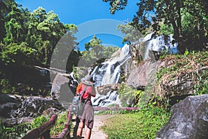 Asian women travel nature. Travel relax. Photograph waterfall travel. In the summer. Thailand