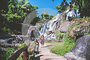 Asian women travel nature. Travel relax. Photograph waterfall travel. In the summer. Thailand