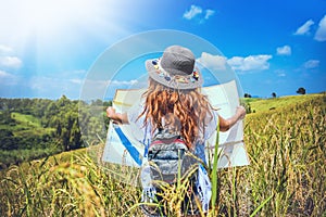 Asian women travel relax in the holiday. Stand natural touch mountain field summer. View map travel explore. In Thailand photo