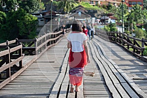 Asian women traveler get dress traditional costume of Mon tribal at Mon village, Sangkhlaburi, Kanchanaburi, Thailand, traveling