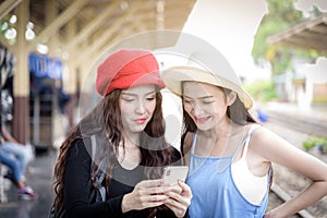 Asian women traveler have playing a mobile phone and talking for