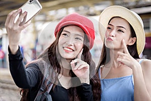 Asian women traveler have playing a mobile phone and talking for