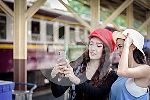 Asian women traveler have playing a mobile phone and talking for