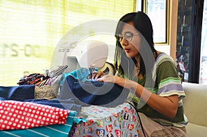 Asian women use machine sewing clothes