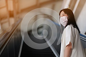 Asian women wear surgical face masks to protect The Covid-19 in public areas