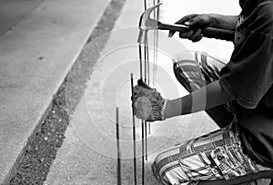 Asian worker with a hammer and steel rod in black and white