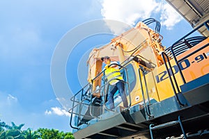 Asian worker on shovel excavator construction site