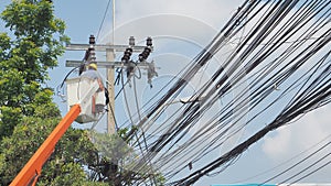 Asian worker to change new electricity pole in the cable car has