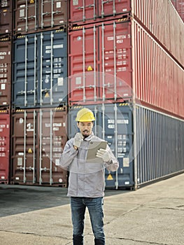 Asian worker using walkie talkie communicate with container team