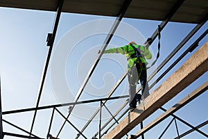 Asian worker wear safety height equipment to install the roof in the construction site;. Fall arrestor device for worker with