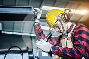 Asian worker wearing the goggle, helmet, ear muff equipment in production plant